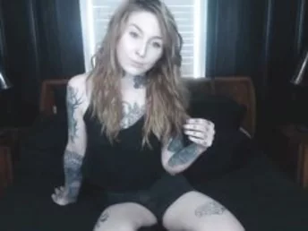 Ginger-haired bony girl with tattoo stripping and posing his slender body and bald cunt.